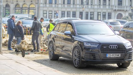 Мениджър с луксозен джип следи ремонта на жълтите павета