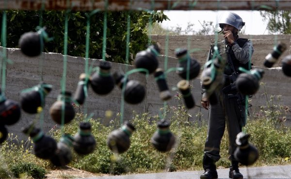 Израелски войници зад празни сълзотворни гранати по време на протест на палестинци в Западния бряг. Снимка: БГНЕС