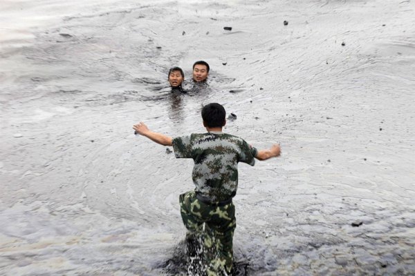 Работници бяха всмукани от водата при опит да ремонтират подводна помпа по време на операция по почистването на нефтен разлив в пристанището Далиан, Китай. Снимка: БГНЕС