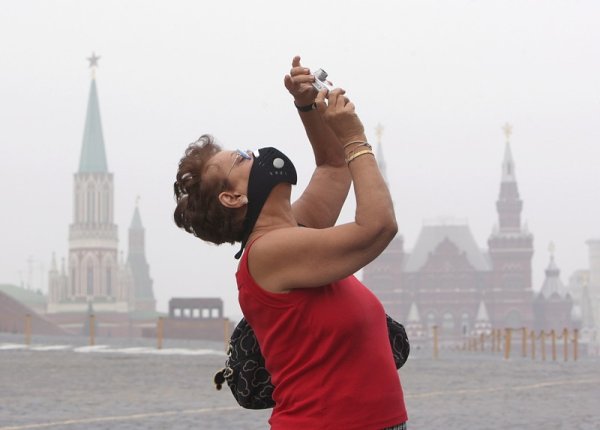 Туристи снимат Червен площад в Москва, покрит от пушек от горските пожари. Снимка: