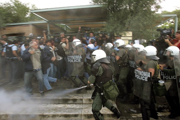 Полицаи разпръскват тълпа от протестиращи по време на поредния протест в гръцката столица Атина. Снимка: БГНЕС