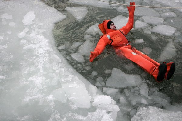 Изследователи и водолази тренират спускане със специални костюми в замръзнало езеро край полския град Гдиня. Снимка: БГНЕС