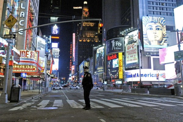 Самотен полицай в Ню Йорк стои пред празния Тайм Скуеър в мегаполиса. Сигнал за поставена бомба опразни площада, който по принцип е пълен с хиляди туристи. Снимка: БГНЕС