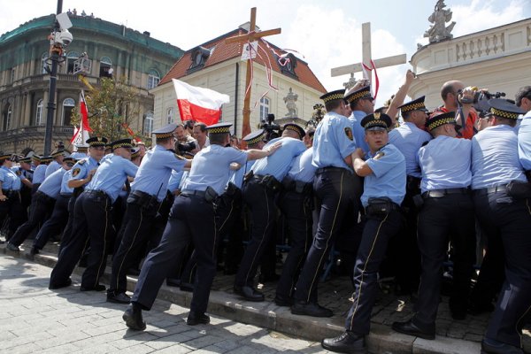 Полицията в полската столица Варшава се опитва да спре похода на протестиращи, обявили се срещу премахването на дървения кръст в памет на загиналия президент Лех Качински. В началото на август новоизбраният президент Бронислав Коморовски поиска кръстът да бъде премахнат от президентската резиденция в съседната църква &quot;Св. Анна&quot;. Снимка: БГНЕС