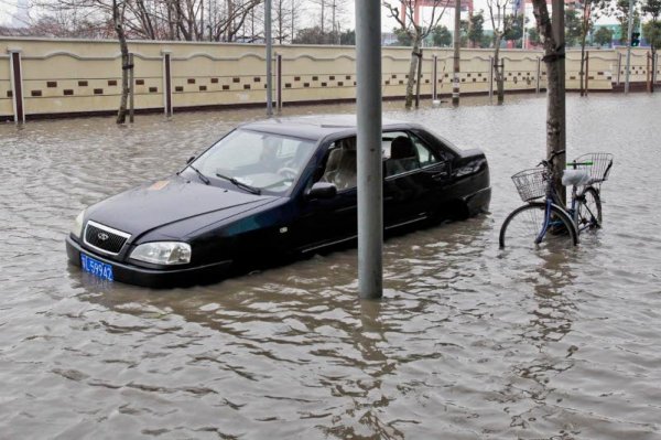 Колело и лек автомобил са залети от придошлата вода в Шанхай, Китай. Снимка: Getty Images/Guliver Photos