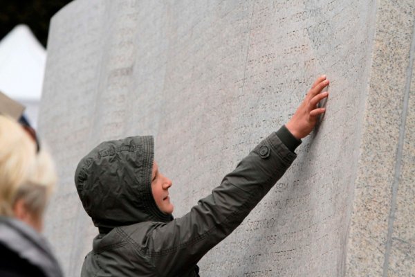 Жена докосва монумента, посветен на жертвите на самолетната катастрофа край Смоленск, на варшавското гробище Повазки. Полша отбелязва първата годишнина от катастрофата, в която загинаха президентът на страната Лех Качински и съпругата му. Снимка: Reuters