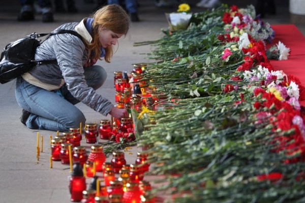 Млада жена пали свещ до входа на метростанция „Октябърская“. При атентата в понеделник загинаха 12 души. В болниците в Минск в момента се намират 151 души, като 40 от тях са в тежко състояние. Снимка: БТА