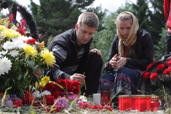 Руска двойка пали свещ близо до летището в Петрозаводск, където преди ден при самолетна катастрофа на самолет Ту-134 загинаха 44-ма души. Снимка: БТА