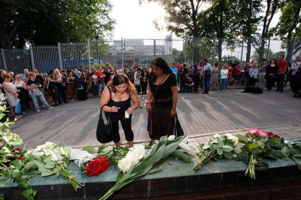 Жена пали свещ докато шведски мюсюлмани са се събрали пред послоството на Норвегия в Стокхолм, за да отдадат почит към жертвите на нападенията. Снимка: Reuters