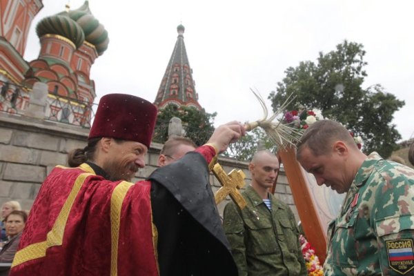 Свещеник пръска за здраве руски войници по повод Деня на парашутиста в столицата Москва. Снимка: БТА