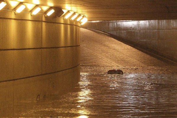 Покривът на кола се подава от водата, заляла тунел в гр. Виго, Испания. Силният дъжд потопи улиците, оставяйки в капан много автомобили и наводнявайки магазини и приземни етажи. Снимка: БТА