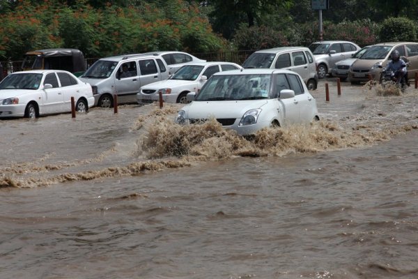 Коли се опитват да си проправят път сред водата, която е заляла улиците на столицата на Индия – Ню Делхи. Снимка: БТА