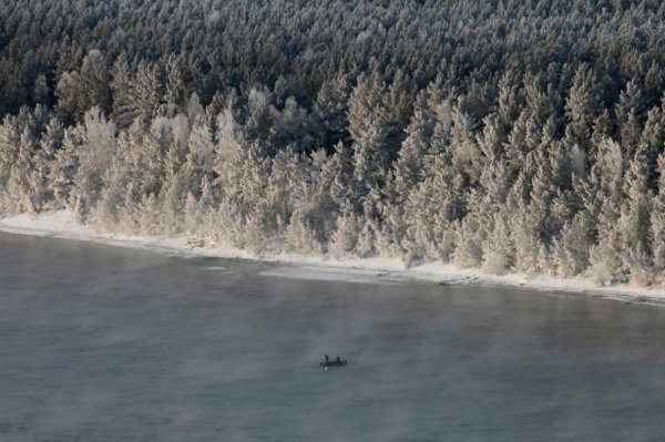 Мъже ловят риба с лодка в почти замръзналите води на река Енисей край руския град Красноярск. Снимка: Reuters