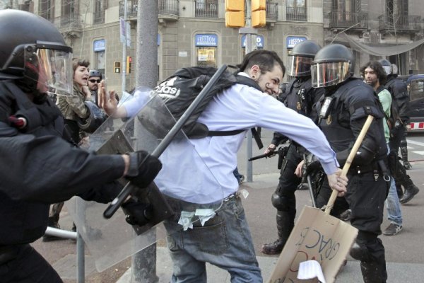 Испански полицаи налагат протестиращ младеж в центъра на Барселона по време на 24-часовата национална стачка, парализирала страната в четвъртък. Снимка: БТА