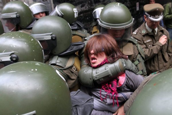 Полицаи арестуват млада жена по време на протест срещу високите и недостъпни цени за образование в столицата на Чили – Сантяго. Снимка: БТА