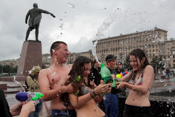 Млади руснаци се забавляват, пръскайки се с вода на централен площад в Санкт Петербург. Снимка: БТА