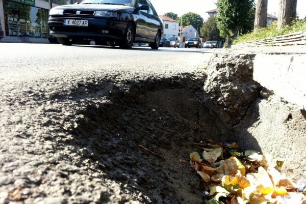 Огромна дупка дебне хасковски шофьори на голяма улица в града. Началниците на полицейските управления и застрахователните дружества своевременно трябва да уведомяват Кмета на общината при ПТП с имуществени щети, причинени от неравности по пътната настилка. Това предложение на кмета Георги Иванов бе одобрено на днешната сесия на Общинския съвет.  Снимка: Impact Press Group