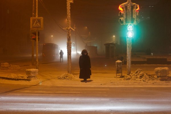 Жена пресича улицата близо до светофар и пътни знаци, покрити с лед, при температура от минус 46 градуса в град Якутск в Източен Сибир. Снимка: Reuters