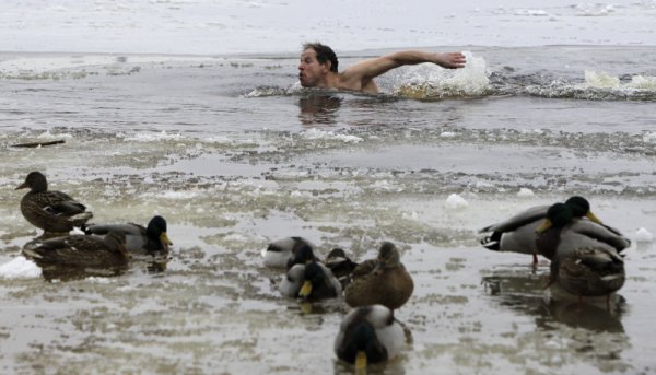 Човек плува в полузаледените води на река Днепър в Украйна. Снимка: БТА