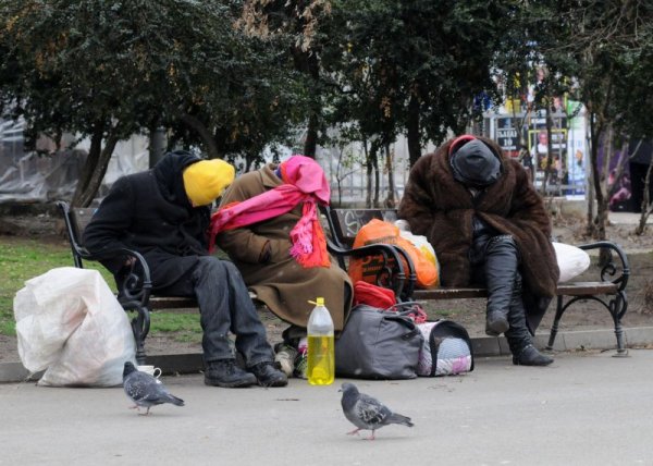 Трима бездомници образуваха сюрреалистична картина в централна софийска градинка. Две жени и мъж кротко седяха на пейка, увили всеки сантиметър от телата си в опит да се предпазят от бръснещия вятър. Снимка: Булфото