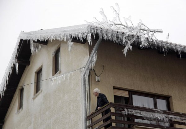 Жител гледа от терасата си как всичко е сковано в лед. Снимка: Reuters