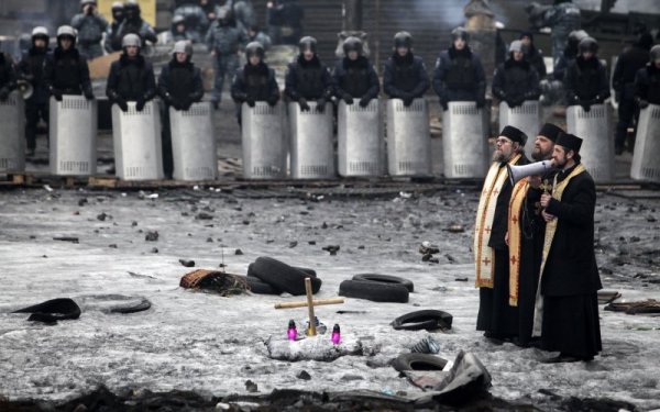 Свещеници говорят по мегафон по време на протестите в Киев, Украйна. Снимка: Reuters