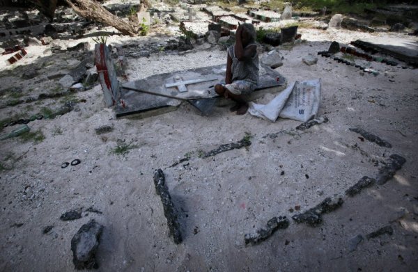 Жена оплаква свой близък на гробищен парк в страната. Поради малката територия на страната и подпочвените води намирането на място за гробища също е много сериозен проблем. Снимка: Reuters