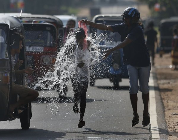 Мъж полива с вода участник в маратон в Шри Ланка. Снимка: Reuters