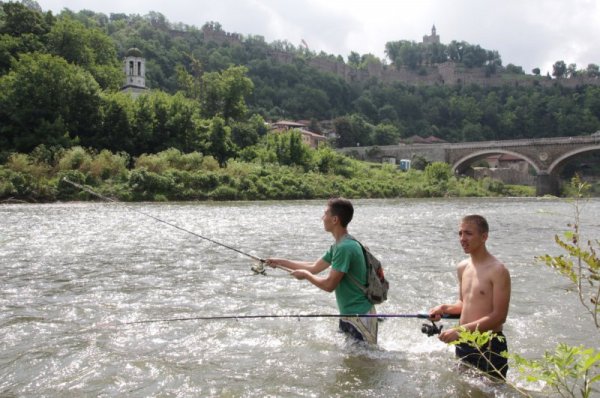 Момчета опитват слуката си във водите на река Янтра край Велико Търново. Освен надеждата за добър улов, рибарите отмарят в хладните води на реката. Снимка: Impact Press Group