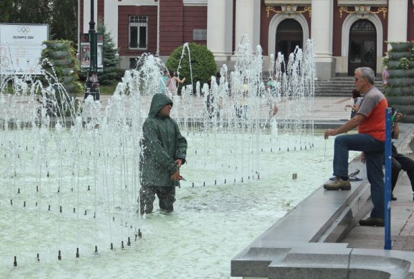 Интересна гледка събуди любопитството на софиянци на фонтана пред Народния театър. Облечен в гумирани дрехи мъж се разхождаше между бликащите струи с клещи в ръка. Оказа се, че от Столична община прочистват струйниците на фонтана, запушени с листа от бурята. Снимка:  Булфото