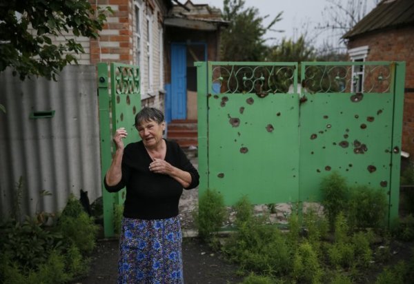 Жена плаче, защото къщата &#1117; е пострадала при обстрела в Семьоновка. Снимка: Reuters