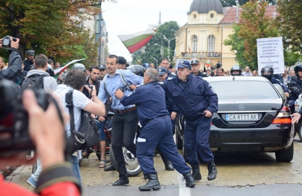 Полицаи изблъскват граждани от пътя на служебния автомобил на вътрешния министър Цветлин Йовчев по време на протестите. Снимка: Булфото