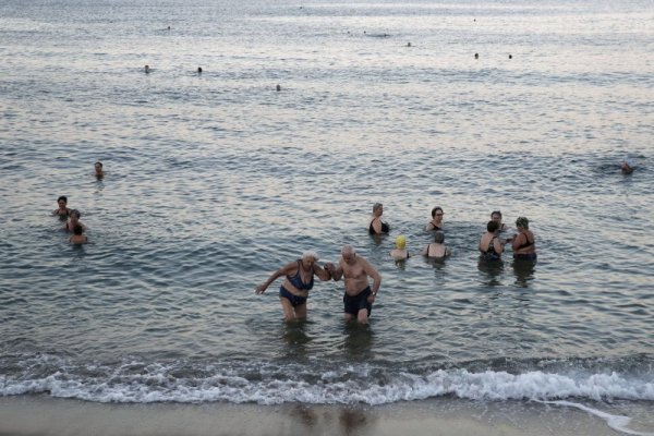 Възрастен мъж помага на своята половинка да излезе от водата на плаж край гръцката столица Атина. Хиляди туристи от различни страни почиват пред август по гръцкото крайбрежие. Местните власти обаче са обезпокоени, че сериозно се е повишил броят на фаталните инциденти спрямо миналата година. Снимка: БТА