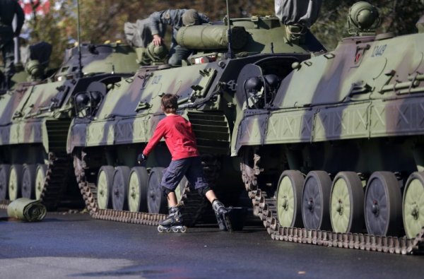 Момче кара ролери край паркирани танкове в сръбската столица Белград. На 16 октомври в града ще се проведе голям военен парад, с който ще се отбележат 70 години от освобождаването на Белград по време на Втората световна война. Снимка: БТА