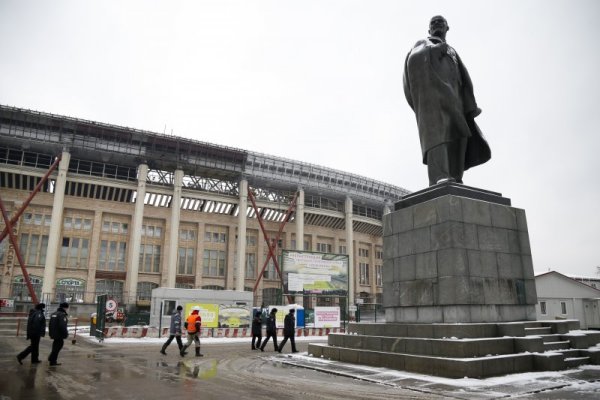 Полицаи и работници вървят край статуя на Ленин до стадион Лужники в Москва. Спортното съоръжение, което ще приеме финала на Световното първенство по футбол през 2018 година, бе проверено от представители на ФИФА, които останаха доволни от работата по стадионите за шампионата след 4 години. Снимка: БТА