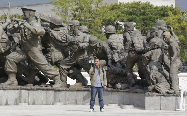 Кореец си прави селфи пред паметник на загиналите в Корейската война в Сеул. Снимка: БТА