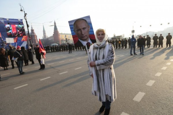 Привърженичка на президента на Русия Владимир Путин държи неговия образ по време на шествие в столицата Москва по повод Деня на народното единство. Снимка: БТА