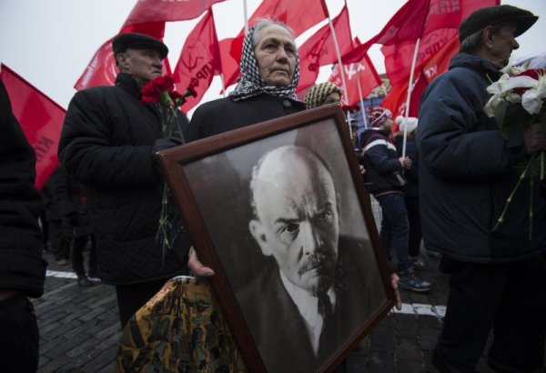 Възрастна жена носи портрет на Владимир Ленин по време на шествие в центъра на Москва. На 7 ноември се навършват 97 години от Болшевишката революция в страната. Снимка: БТА