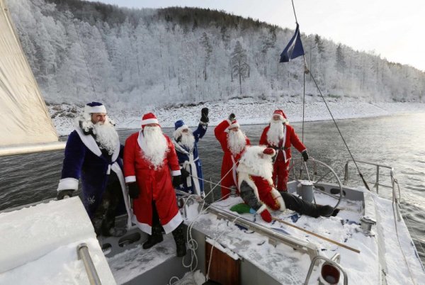 Членовете на яхт клуба Skipper, преоблечени като Дядо Мраз, поздравяват екипажа на друга лодка на река Енисей край сибирския град Красноярск, Русия. Снимка: Reuters