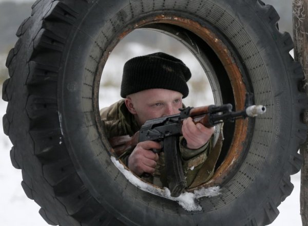 Новобранец от украинската армия се готви да стреля с автомат по време на военно обучение в база, намираща се на 100 км от столицата Киев. Снимка: БТА