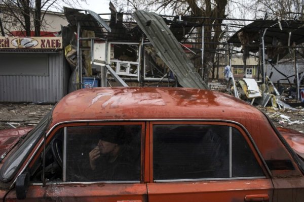 Мъж пуши цигара в колата си, паркирана в близост до разрушен магазин в Донецк, Украйна. Снимка: Reuters