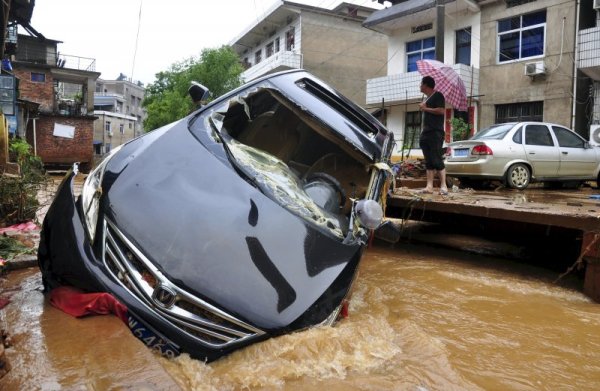 Кола е отнесена от придошлите води след поройни дъждове в град в китайската провинция Дзянси. Снимка: Reuters