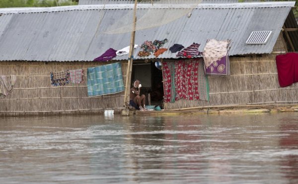 Дете се къпе на прага на наводнената си къща. Придошли води убиха няколко човека в североизточна Индия и оставиха без дом над 800 000 души. Снимка: БТА