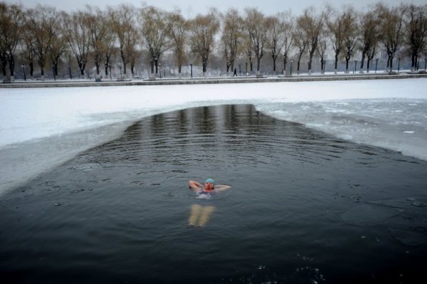 Жена плува в ледените води на езеро в китайската провинция Ляонин въпреки минусовите температури. Снимка: БТА