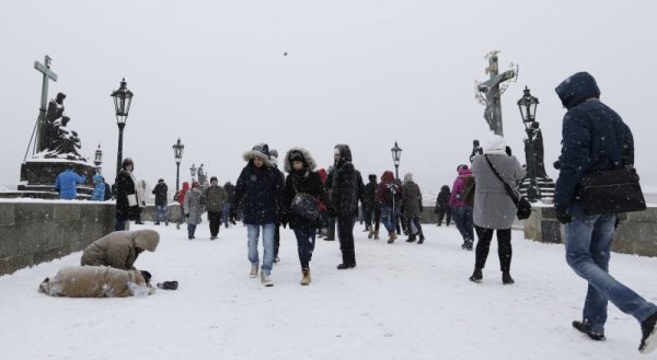 Туристи преминават през Карловия мост в Прага в студения зимен ден в чешката столица. Снимка: БТА