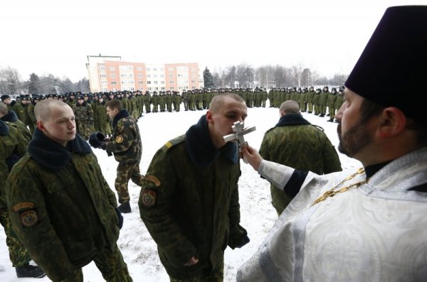 Военни от Беларус целуват светия кръст по време на коледна служба в поделение край столицата Минск. В Беларус днес също е Коледа. Снимка: Reuters