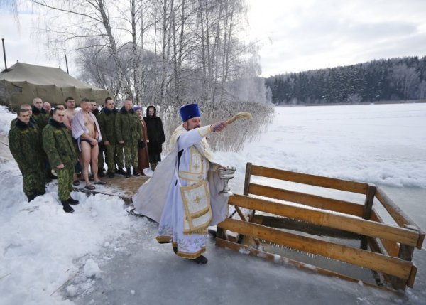 Православен свещеник извършва водосвет преди хвърлянето на кръста в беларуско село. Голяма част от православния свят чества днес Богоявление. Снимка: БТА