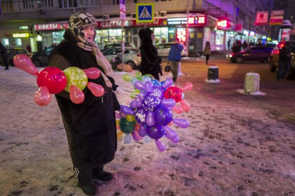 Възрастна жена продава балони в студения зимен ден в Москва, за да спечели малко повече пари към пенсията си. Снимка: БТА