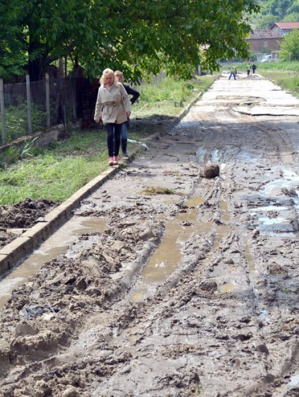 Тежка техника започна почистването на централната част на село Константиново. Пороят, които се изля снощи в района почти напълно унищожи пътната настилка. Наводнени са и няколко къщи Снимка: БТА