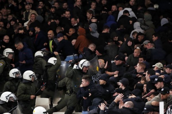 Гръцки полицаи влизат в сблъсък с фенове на холандския гранд Аякс по време на мача срещу АЕК на Олимпийския стадион в Атина. Срещата от Шампионската лига се запомни с множество хулигански прояви от трибуните от страна както на домакини, така и на гости. Снимка: БТА